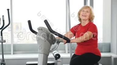 积极健康的衰老。 一位穿着红色t恤的漂亮老年妇女参加体育活动。 老年积极生活